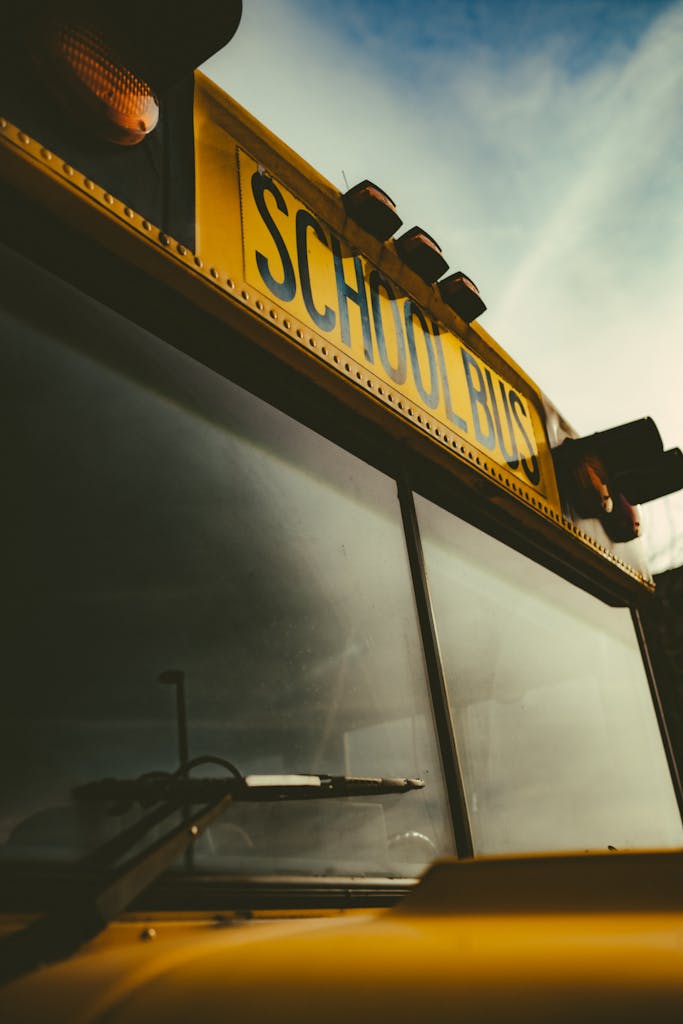 Dramatic low angle shot of a classic yellow school bus against a blue sky